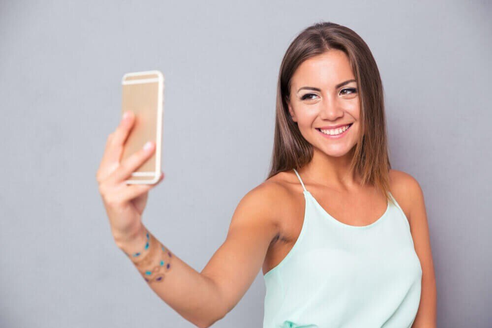 teen rhinoplasty patient model taking a selfie with a mobile phone