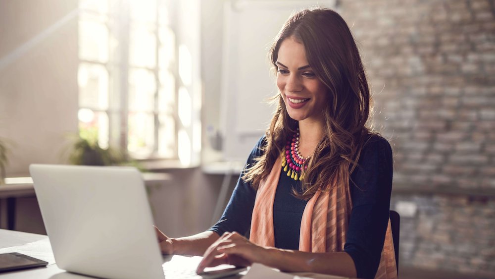 Woman working on her laptop smiling