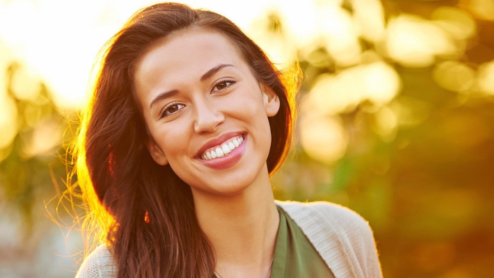 woman smiling witha blurred out background.