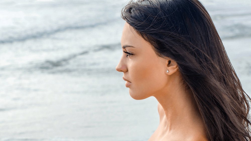 Woman's face from the side while standing on beach