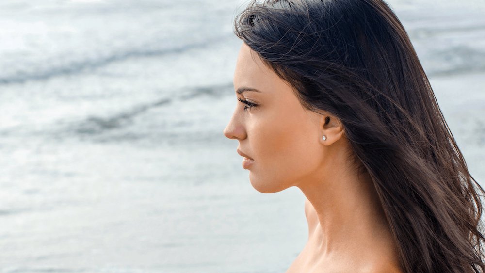 neck lift patient model standing at a beach