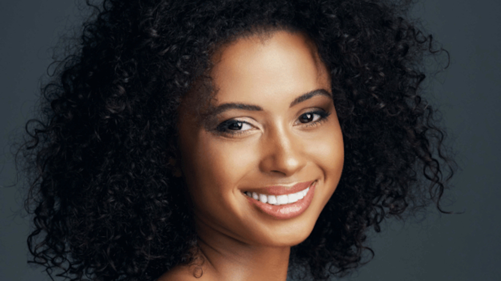 Close up of a woman with curly hair smiling