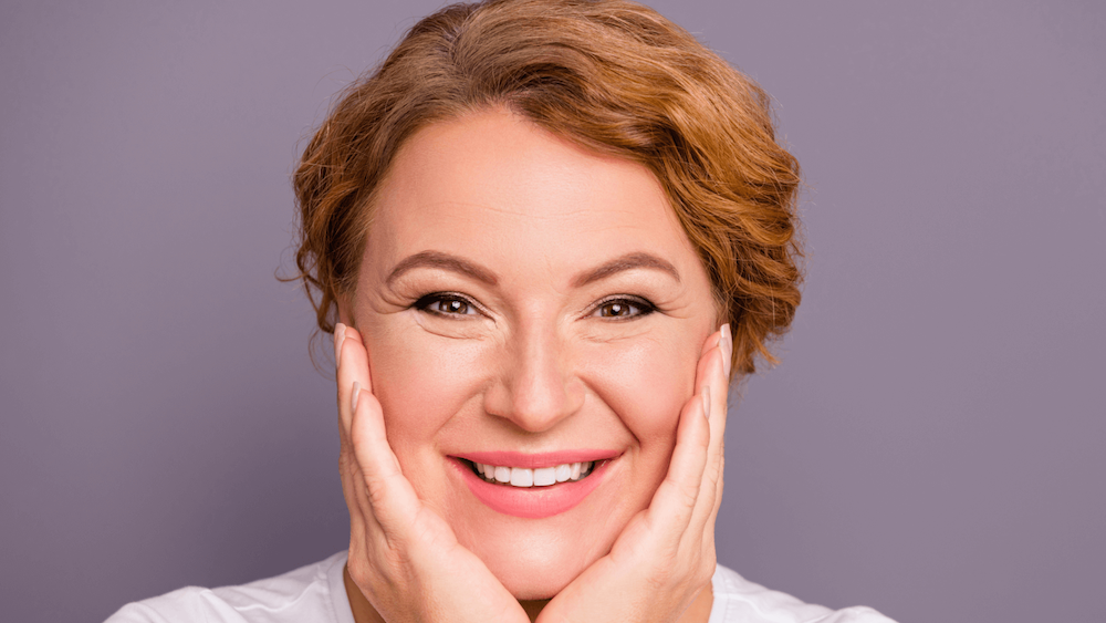 Older Woman Smiling with her head in her hands