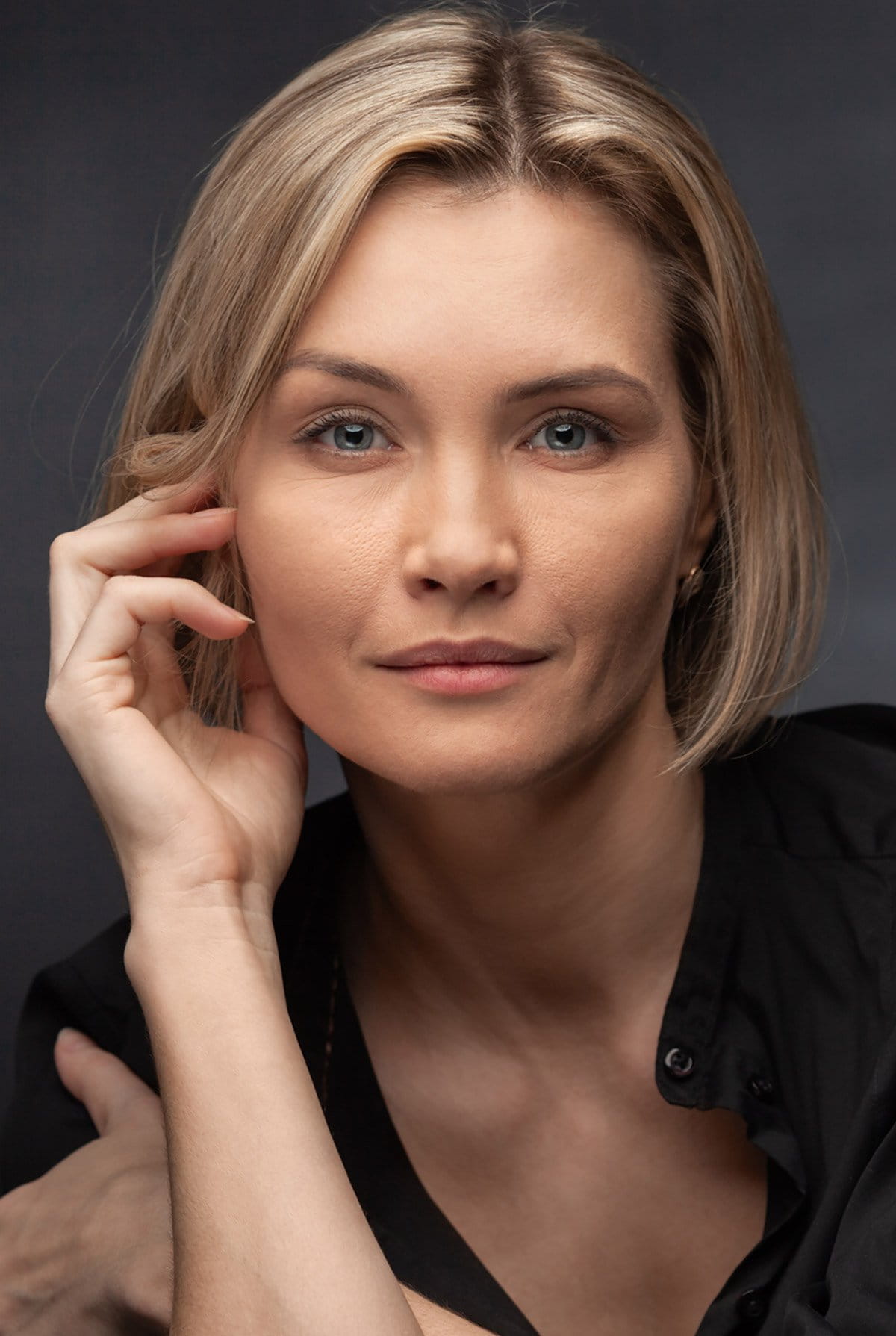 blonde neck lift patient model with her hand to the side of her face