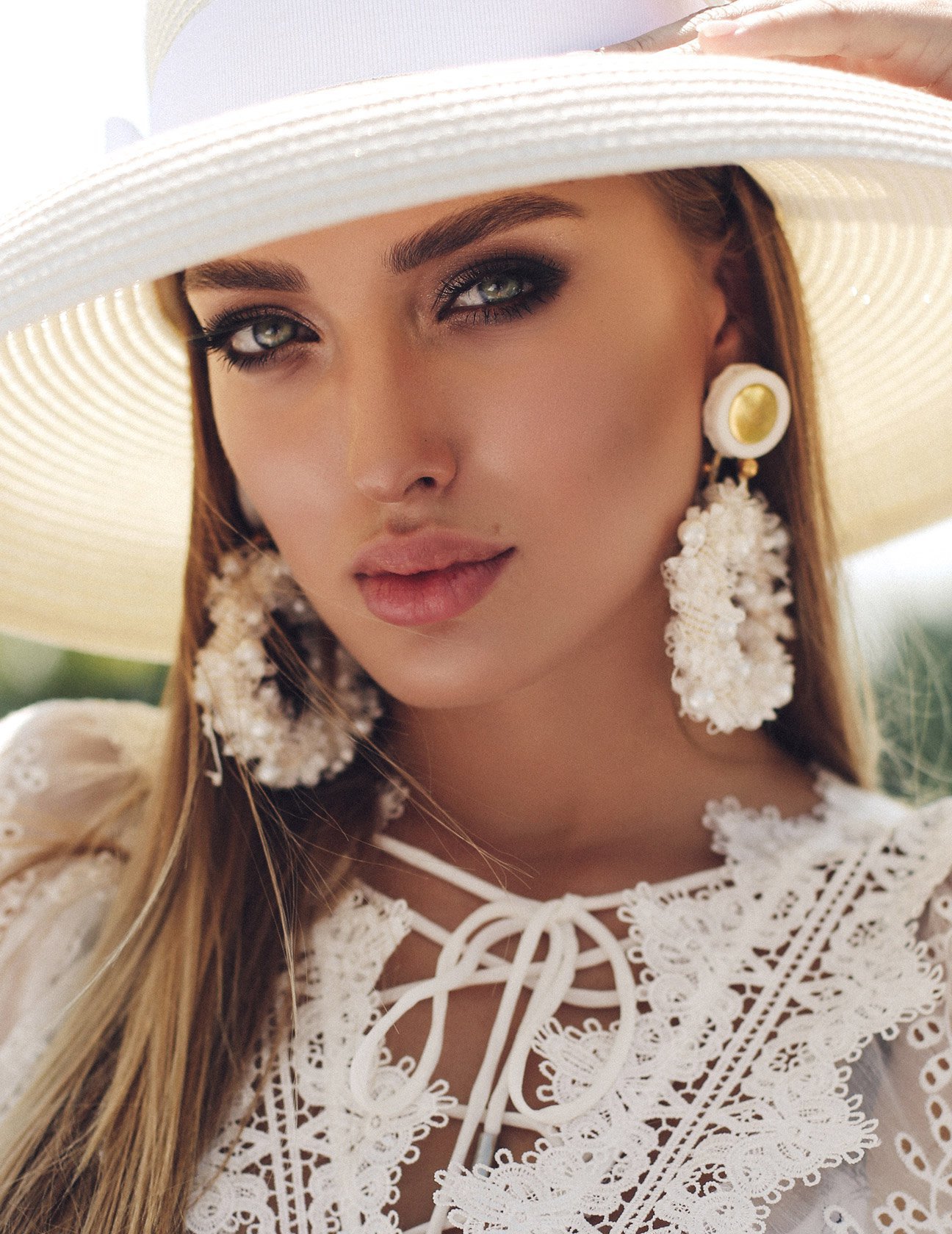 septorhinoplasty patient model in a lacey white top and sunhat